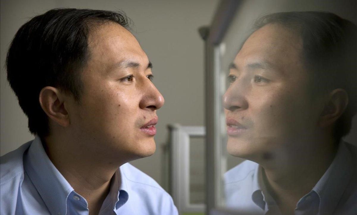 El doctor He Jiankui, reflejado en un panel mientras trabaja con el ordenador. El doctor He Jiankui, reflejado en un panel mientras trabaja con el ordenador.