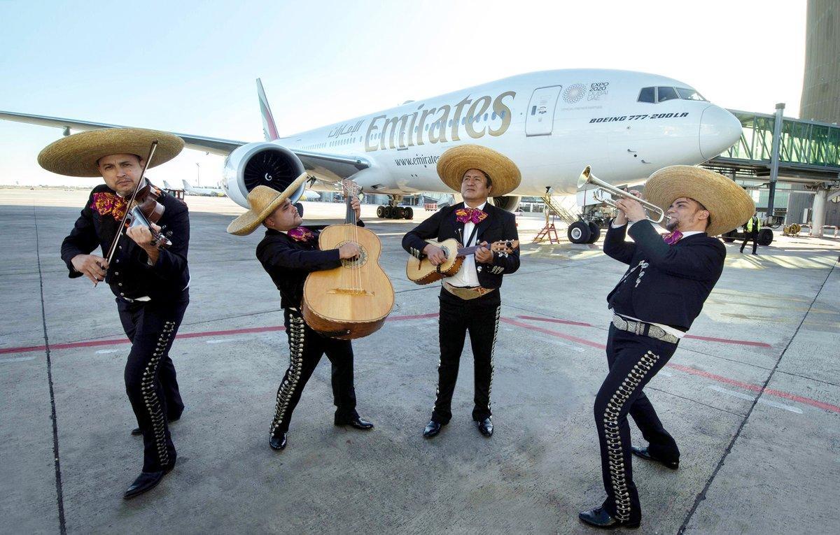 Mariachis en el aeropuerto de El Prat, junto al avión de Emirates que conecta Dubái, Barcelona y México.