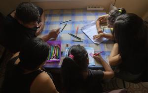 La familia dibujando con sus hijas en el comedor de su casa