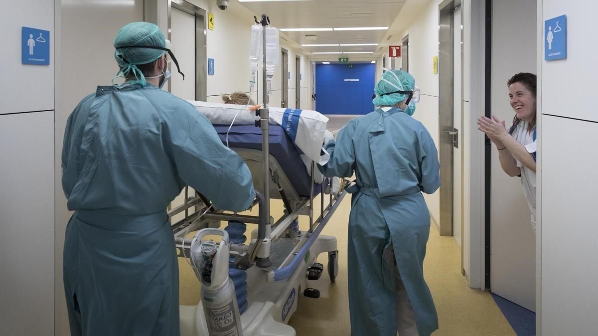 Sanitarios de la Vall d’Hebron aplauden a una mujer dada de alta de la uci. Sanitarios de la Vall d’Hebron aplauden a una mujer dada de alta de la uci.