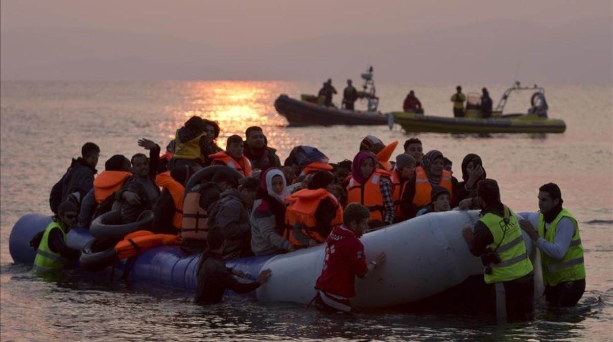 Varios voluntarios ayudan a refugiados a su llegada a la isla de Lesbos. Varios voluntarios ayudan a refugiados a su llegada a la isla de Lesbos.