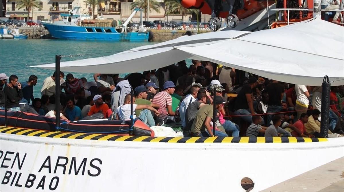 Unos inmigrantes esperan desembarcar de uno de los barcos de Open Arms. Unos inmigrantes esperan desembarcar de uno de los barcos de Open Arms.