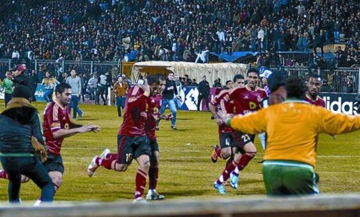 Los jugadores cairotas corren hacia los vestuarios al final del partido, perseguidos por los hinchas locales. Los jugadores cairotas corren hacia los vestuarios al final del partido, perseguidos por los hinchas locales.