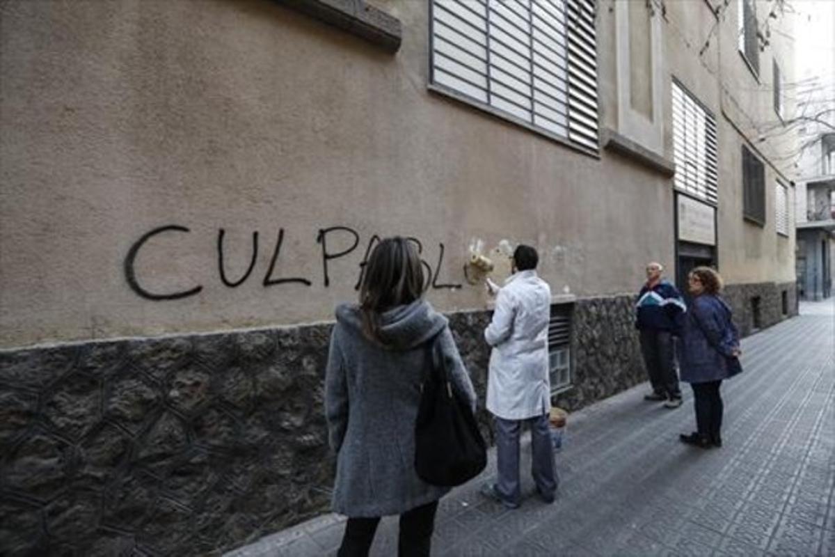 Un empleado de los Maristas Sants-Les Corts borra una pintada en la fachada del centro.