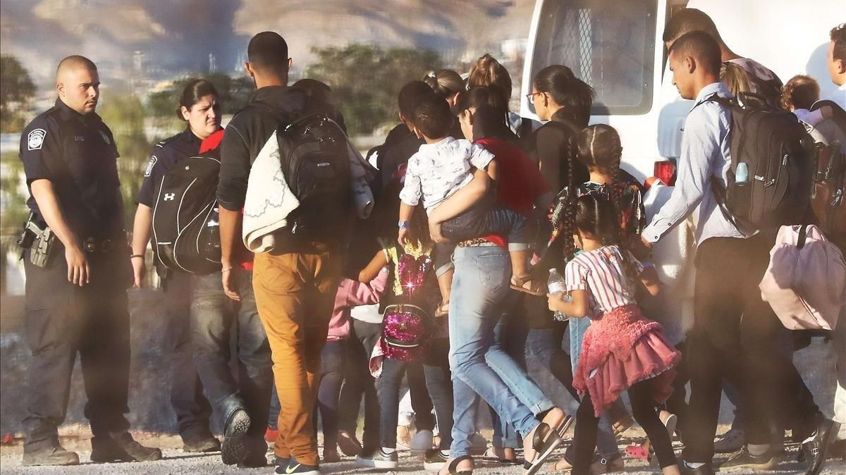 Policías estadounidenses custodian a un grupo de inmigrantes que han sido detenidos por entrar ilegalmente en EEUU. Policías estadounidenses custodian a un grupo de inmigrantes que han sido detenidos por entrar ilegalmente en EEUU.