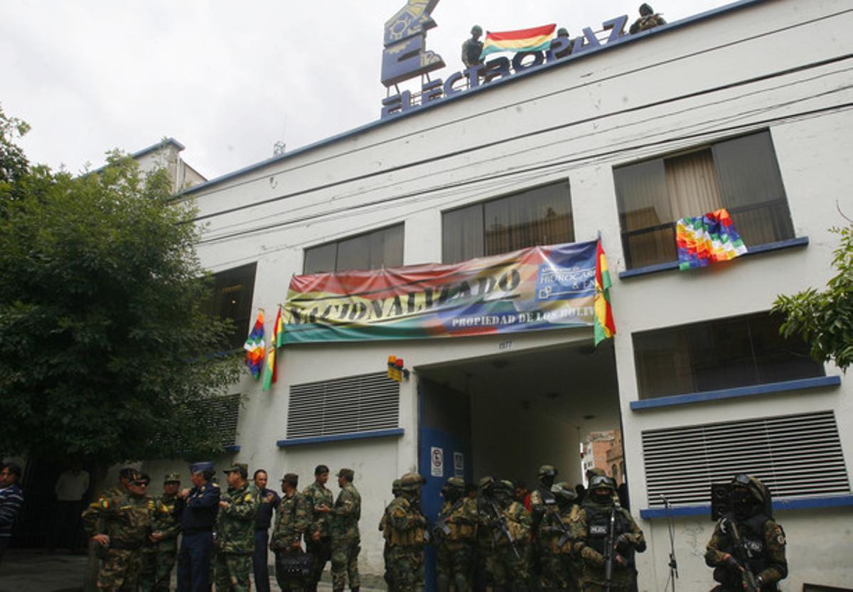 Soldados bolivianos ante la sede de la filial de Iberdrola Electropaz, en la que cuelga el cartel de ’nacionalizado’, este sábado en La Paz.