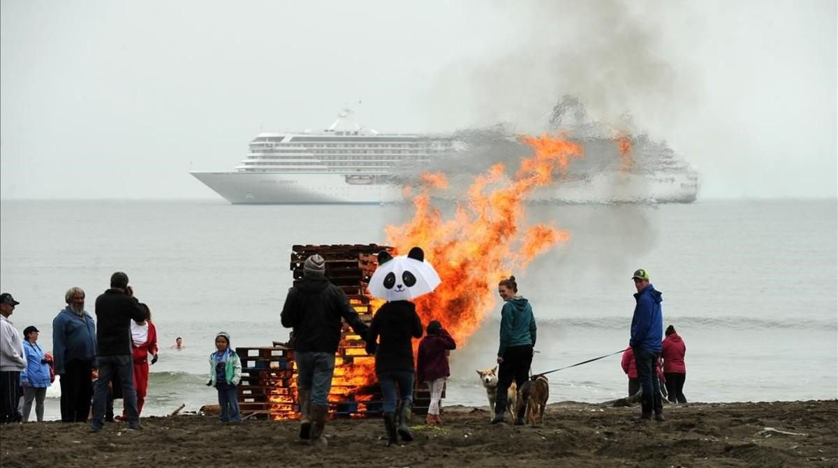 Vecinos de la localidad de Nome, en el mar de Bering, observan a lo lejos del crucero ’Crystal Serenity’. Las hogueras se encienden para dar calor a los bañistas que salen de las gélidas aguas. Vecinos de la localidad de Nome, en el mar de Bering, observan a lo lejos del crucero ’Crystal Serenity’. Las hogueras se encienden para dar calor a los bañistas que salen de las gélidas aguas.