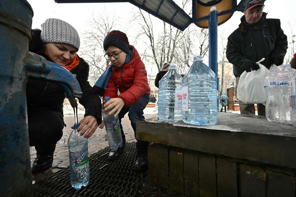 Residentes de Kiev llenan botellas y garrafas de agua, este jueves, tras los ataques que la víspera dejaron sin suministros de luz y agua a la capital.