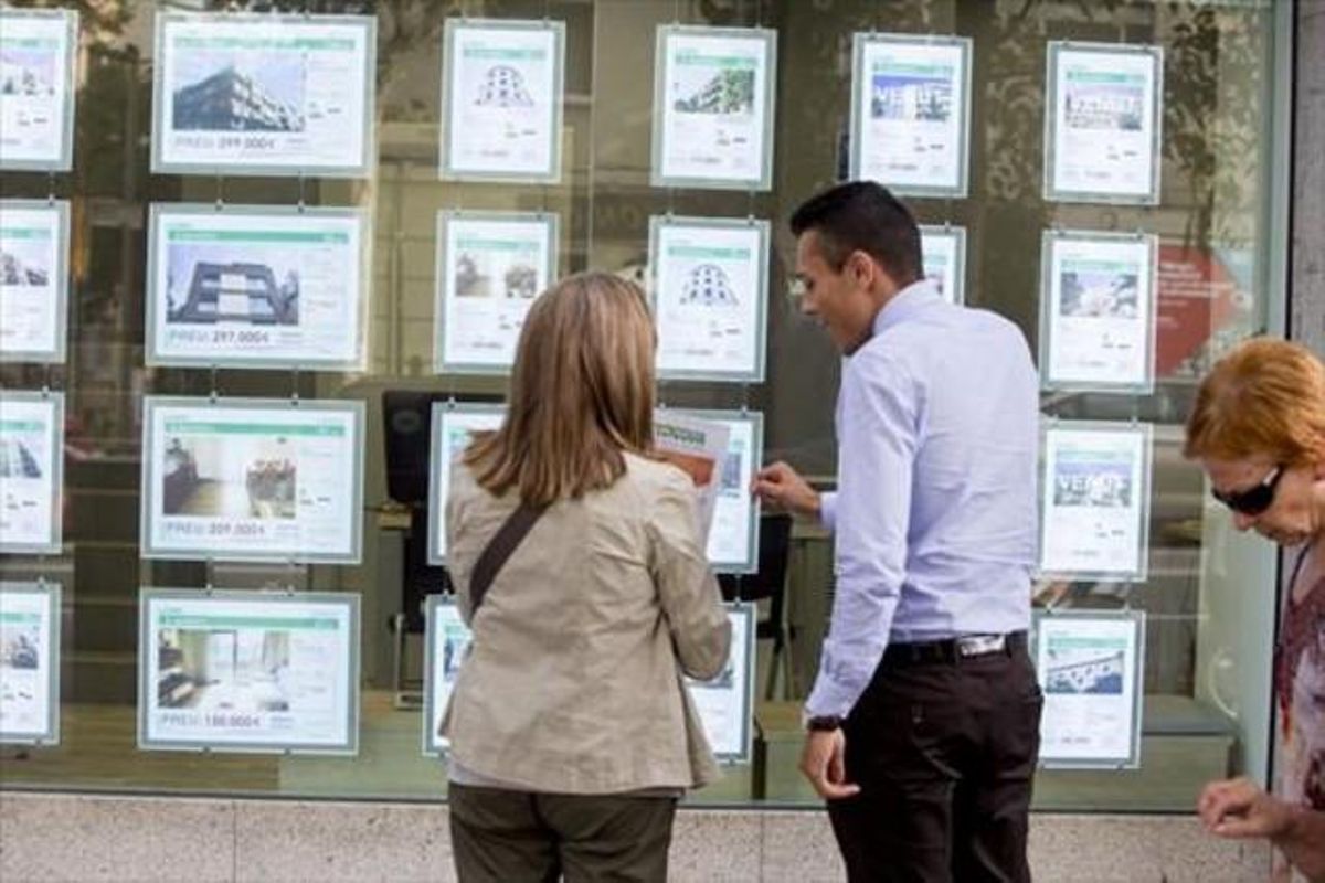 Una clienta y un comercial miran las ofertas de una inmobiliaria. Una clienta y un comercial miran las ofertas de una inmobiliaria.