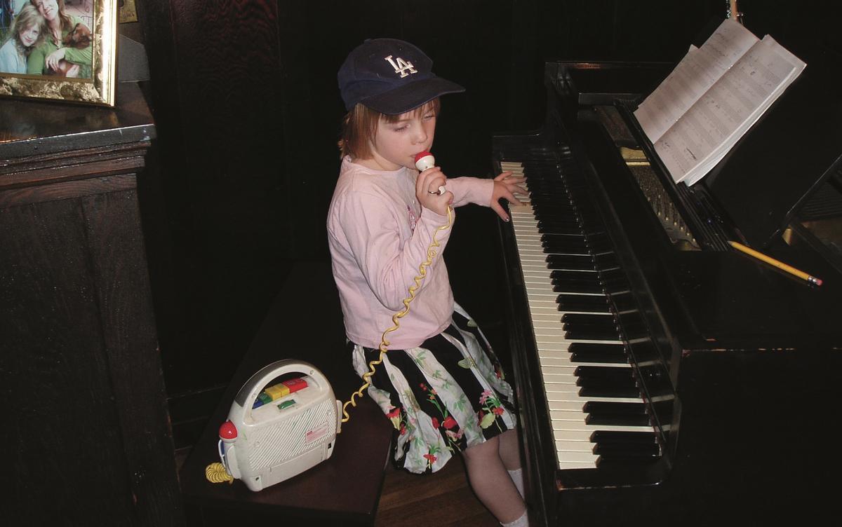 Eilish, con 6 años, tocando en el piano familiar y cantando con un micrófono de juguete.