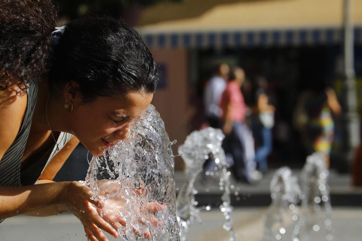 Una mujer se refresca en la fuente de la plaza de las Tendillas de Córdoba ayer cuando se cumplía el quinto día de la tercera ola de calor del verano. EFE/ Salas