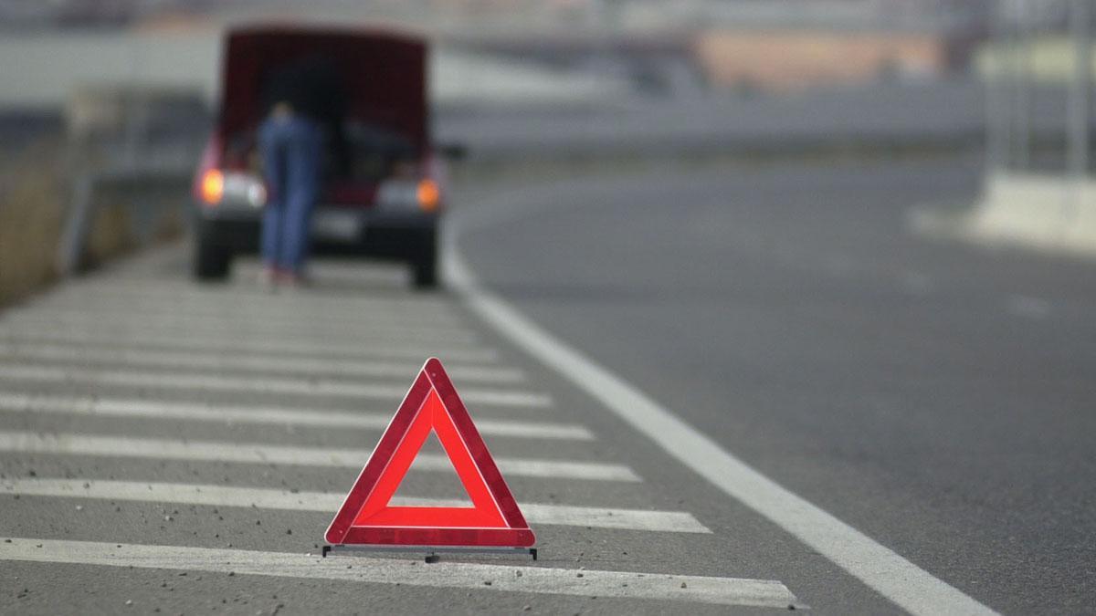 Un conductor señaliza con un triángulo de emergencia una avería en su coche, cerca de Tarragona.