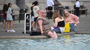 Ciudadanos se refrescan en la fuente de Trafalgar Square, en Londres, ante las elevadas temperaturas en la ciudad.