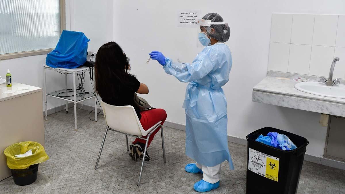Un trabajador de un centro de atención primaria en Barcelona se prepara para hacer una prueba de coronavirus a un paciente.