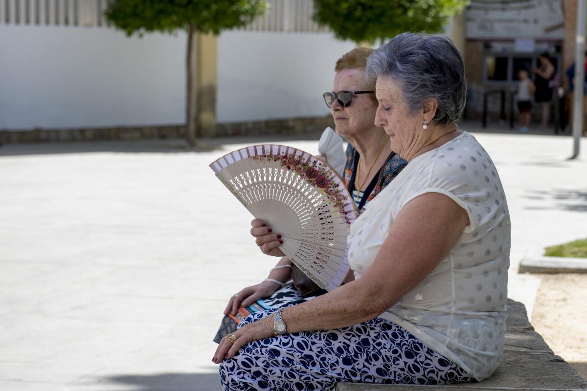 Dos mujeres se refrescan con un abanico durante la ola de calor de este verano en España. 