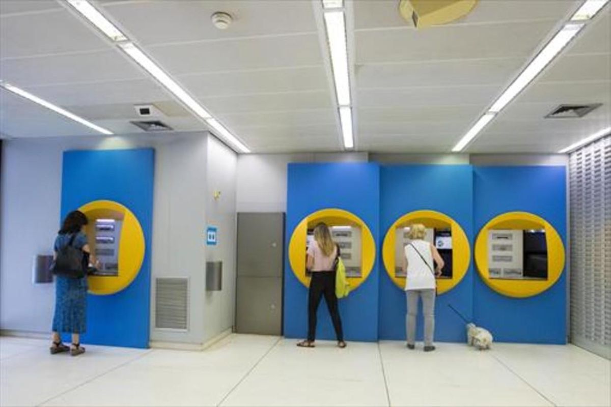Clientes en cajeros de CaixaBank en la sede Barcelona. Clientes en cajeros de CaixaBank en la sede Barcelona.