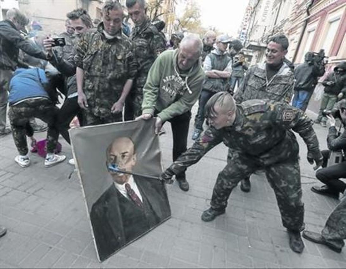 Un miliciano de Maidán daña un retrato de Lenin, el pasado 9 de abril. Un miliciano de Maidán daña un retrato de Lenin, el pasado 9 de abril.