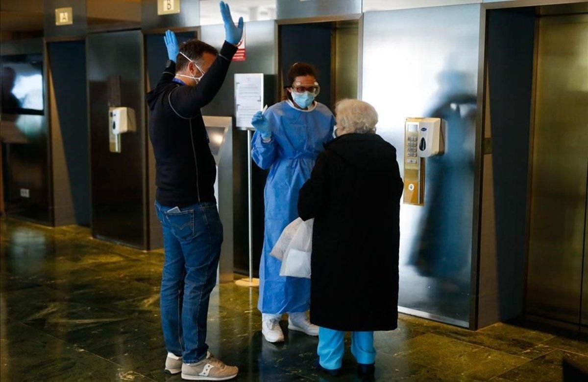 El director del hotel, Enrique Aranda, a la izquierda, y una sanitaria atienden a una paciente en la recepción. El director del hotel, Enrique Aranda, a la izquierda, y una sanitaria atienden a una paciente en la recepción.