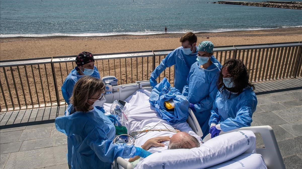 Isidre Correa, junto a su mujer y el equipo médico, frente a la playa delante del Hospital del Mar de Barcelona.