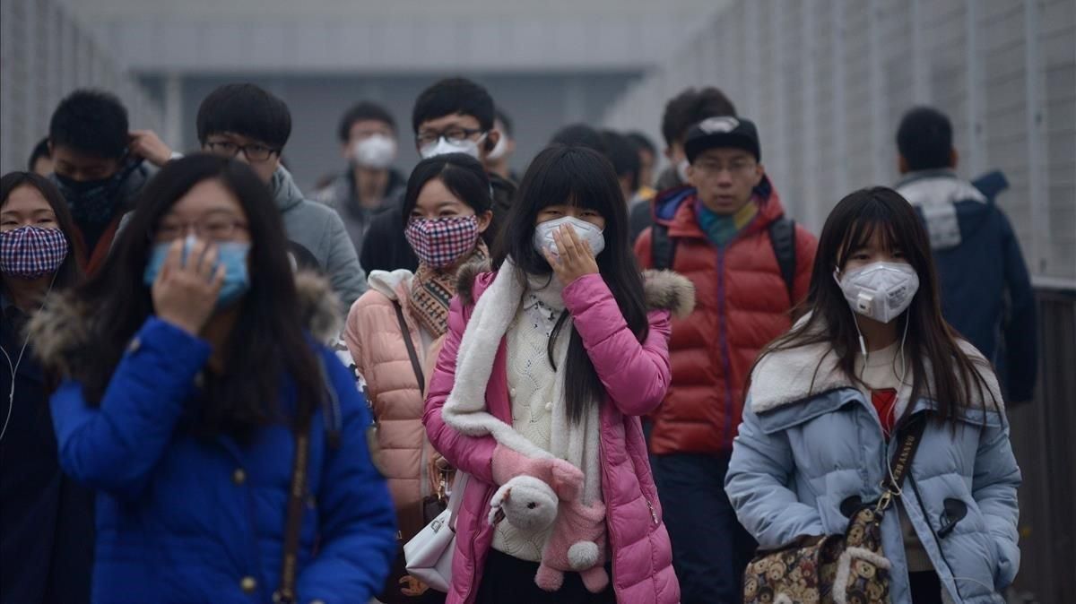 En Pekín, los peatones utilizan mascarillas durante un episodio de alerta de contaminación En Pekín, los peatones utilizan mascarillas durante un episodio de alerta de contaminación