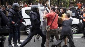 Policías intentando desalojar a personas concentradas ante el colegio Ramon Llull en Barcelona, el 1 de octubre del 2017.