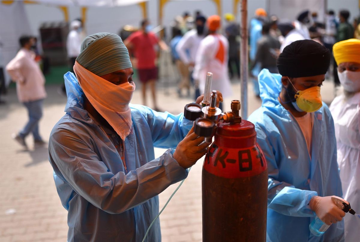 Un sanitario rellena una bombona de oxígeno en un puesto de atención médica en Nueva Delhi. Un sanitario rellena una bombona de oxígeno en un puesto de atención médica en Nueva Delhi.
