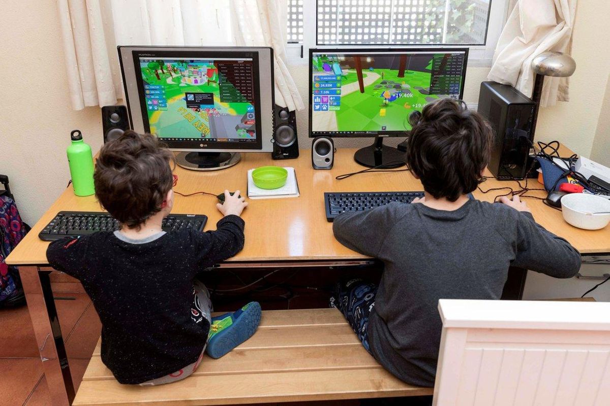 Dos niños juegan en sus ordenadores durante el confinamiento, en Murcia, el 28 de marzo. Dos niños juegan en sus ordenadores durante el confinamiento, en Murcia, el 28 de marzo.