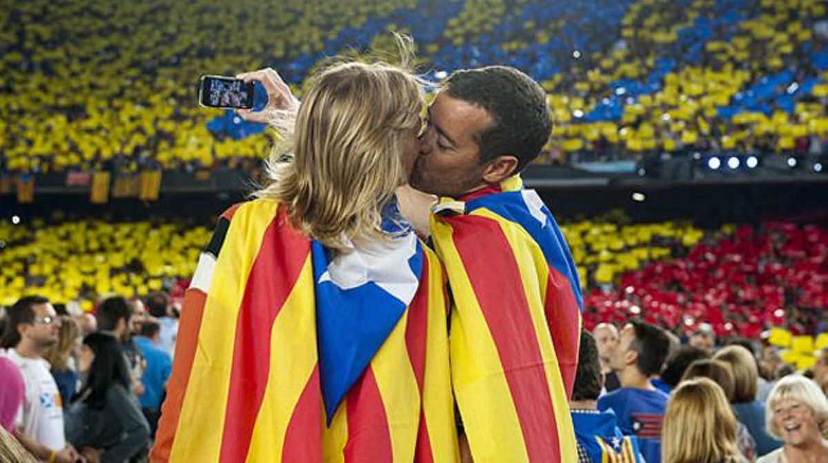 Una pareja con dos ’estelades’ a modo de capa se besa en el Camp Nou. Una pareja con dos ’estelades’ a modo de capa se besa en el Camp Nou.