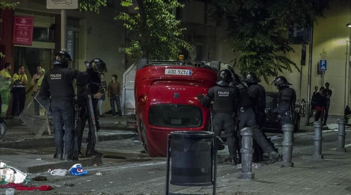 Un coche volcado durante la primera noche de disturbios en Grácia, el lunes pasado. Un coche volcado durante la primera noche de disturbios en Grácia, el lunes pasado.