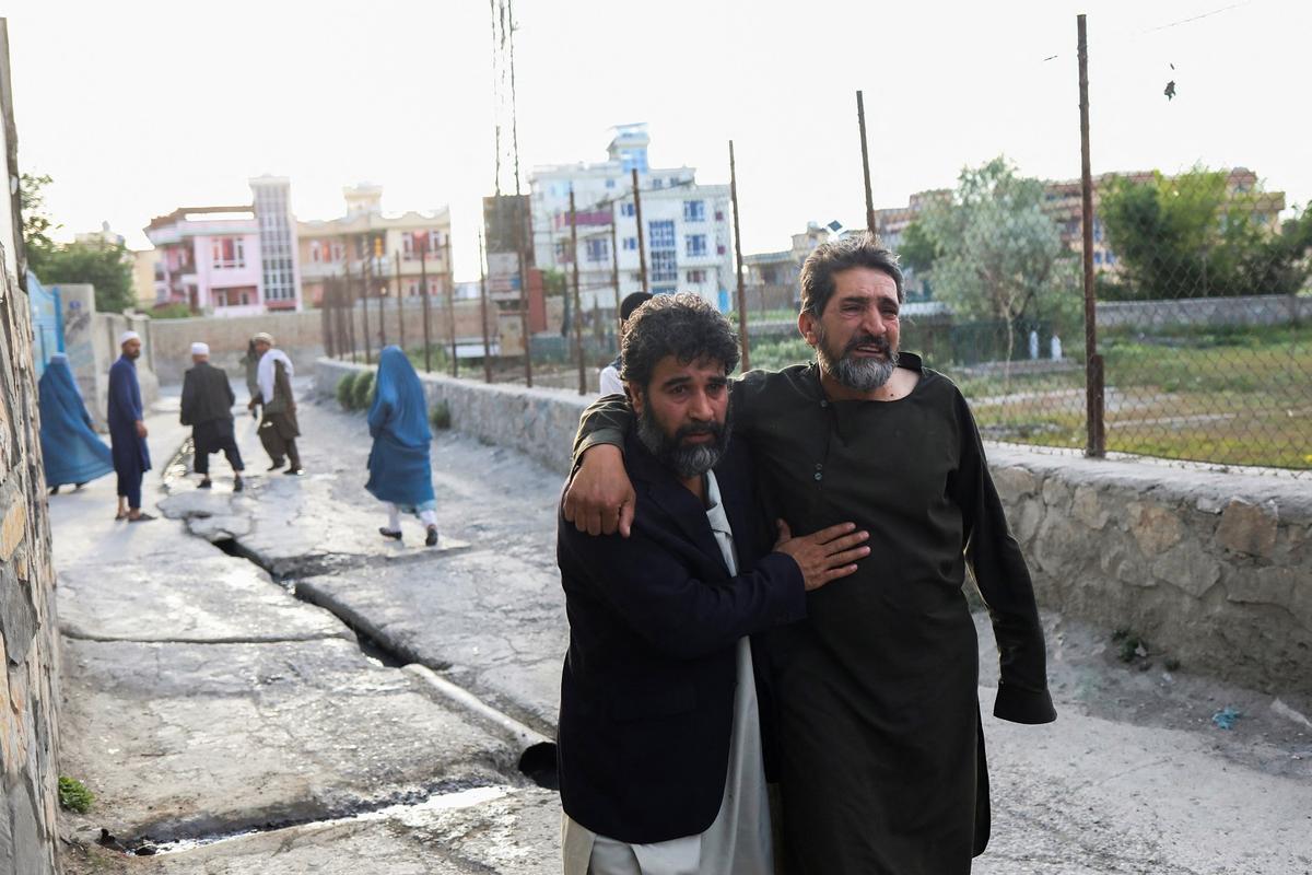 Afganos huyen cerca del sitio de las explosiones de la mezquita Khalifa Sahib en Kabul, ayer.