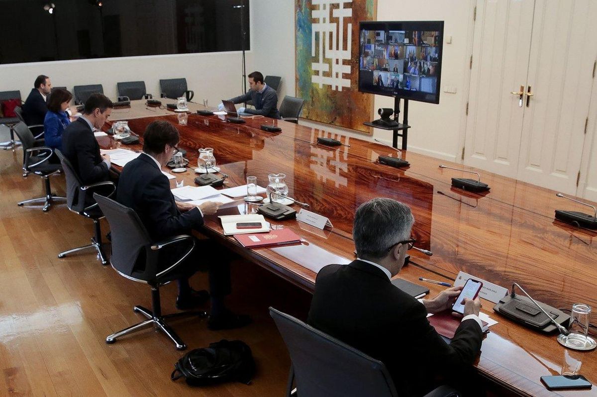 Pedro Sánchez, de espaldas, junto a los ministros Illa, Ábalos y Marlaska, en la videoconferencia con los presidentes autonómicos, este domingo. Pedro Sánchez, de espaldas, junto a los ministros Illa, Ábalos y Marlaska, en la videoconferencia con los presidentes autonómicos, este domingo.