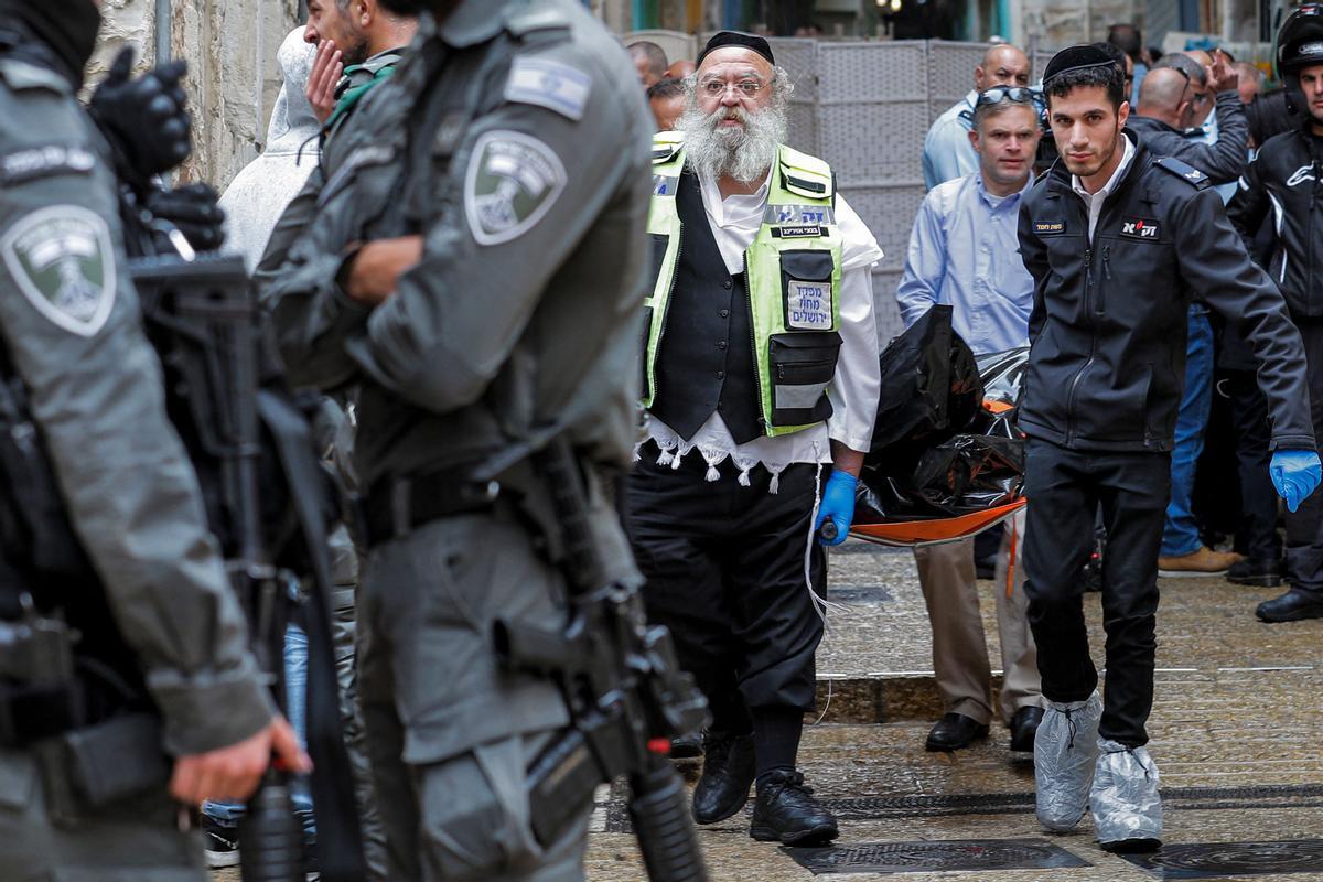 Fuerzas de seguridad trasladas uno de los cadáveres tras el ataque de este domingo en Jerusalén.