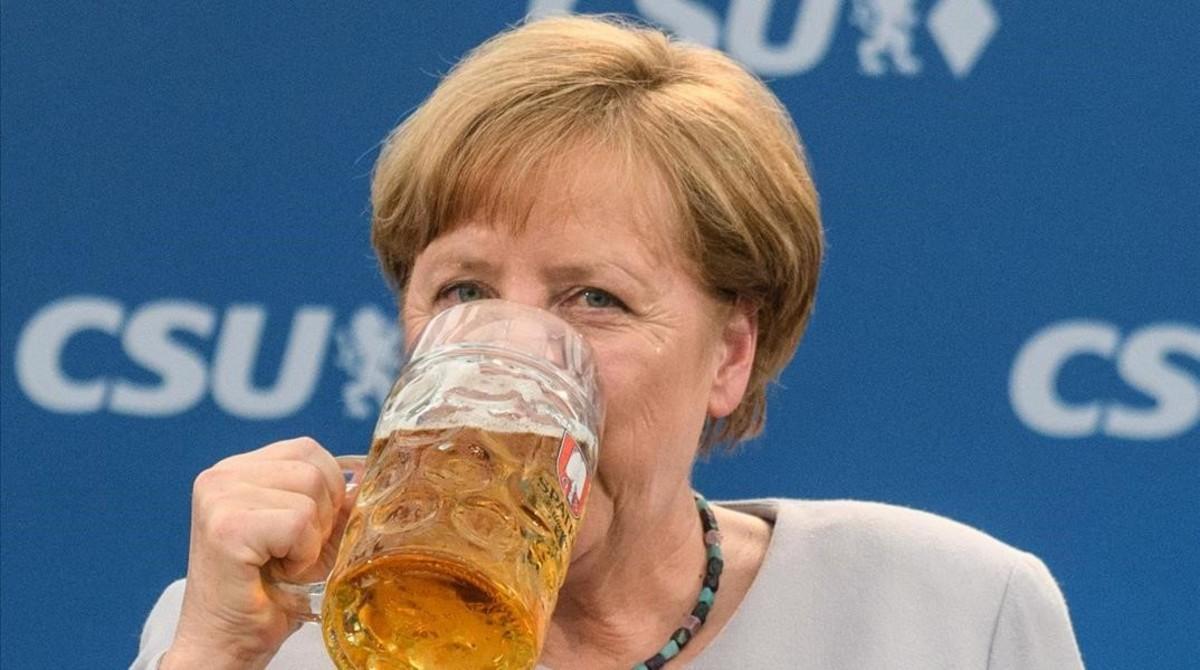 La cancillera alemana bebe una jarra de cerveza tras participar en un mitin en Múnich.