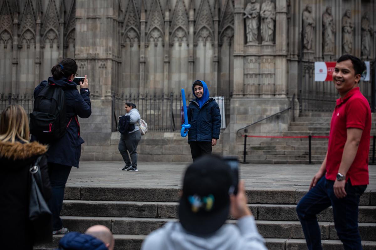 Unos turistas se fotografían delante de la Catedral de Barcelona.