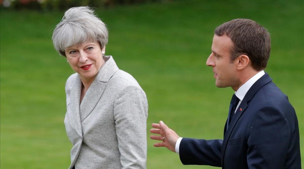 El presidente francés, Emmanuel Macron (derecha), y la primera ministra británica, Theresa May, en los jardines del Elíseo el pasado 13 de junio.