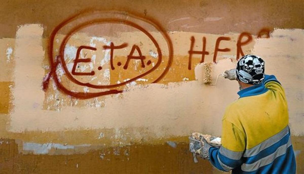 Un técnico de limpieza borra una pintada a favor de ETA en Gernika (Vizcaya), el día después de que la banda terrorista anunciase el cese definitivo de sus acciones armadas.
