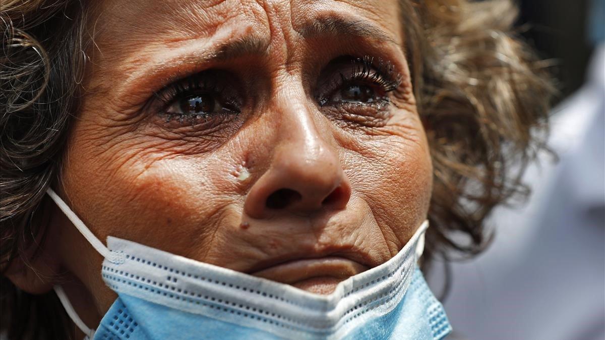 La madre de una persona desaparecida llora angustiada mientras espera noticias de los equipos de rescate que trabajan en el puerto de Beirut.