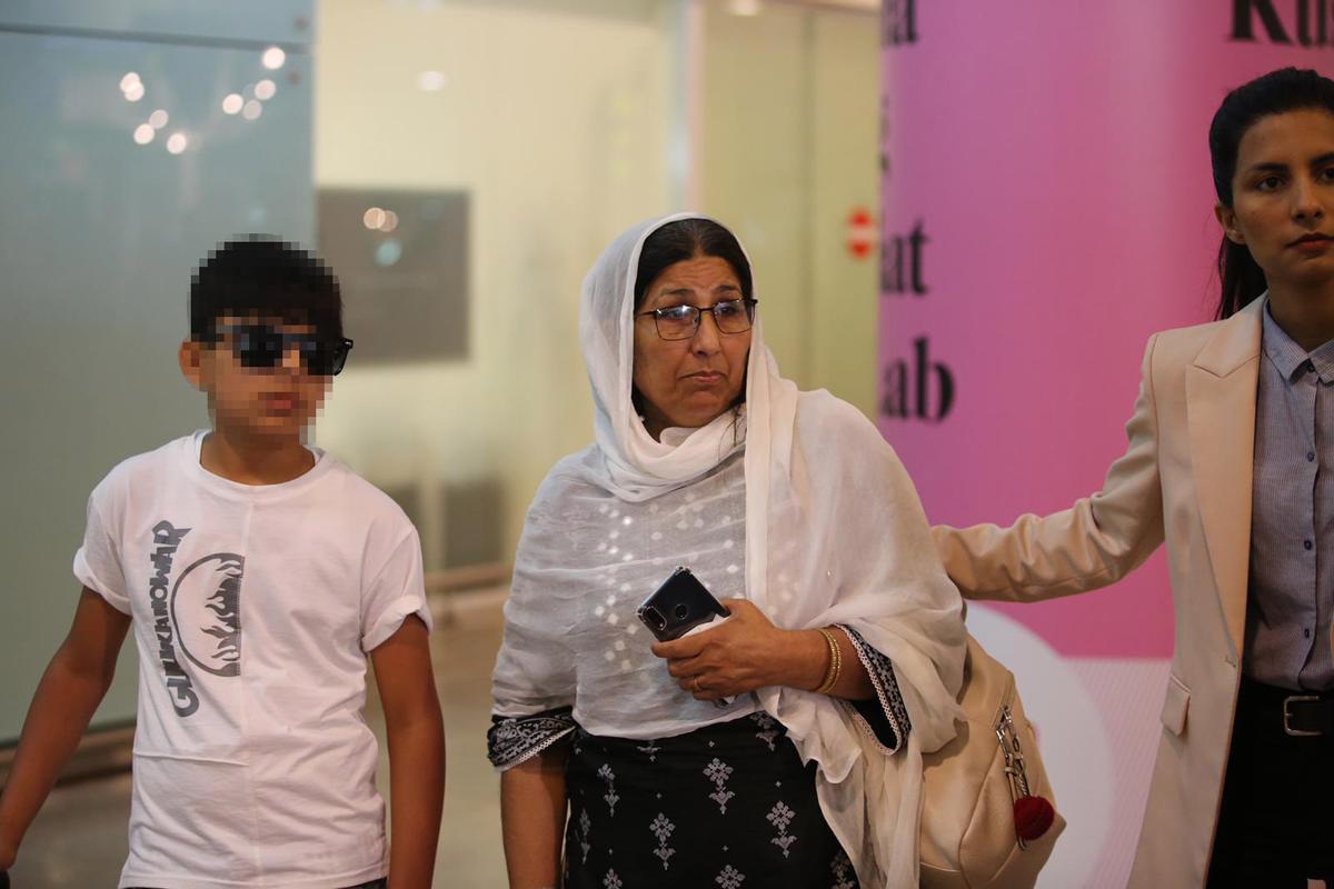 La madre de las dos hermanas de Terrassa asesinadas en Pakistan y su hijo menor, a su llegada al aeropuerto de Barcelona este domingo.
