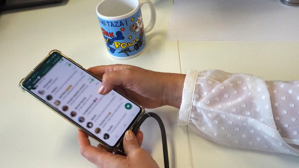 Una mujer mira su listado de conversaciones de Whatsapp en su teléfono móvil. Una mujer mira su listado de conversaciones de Whatsapp en su teléfono móvil.