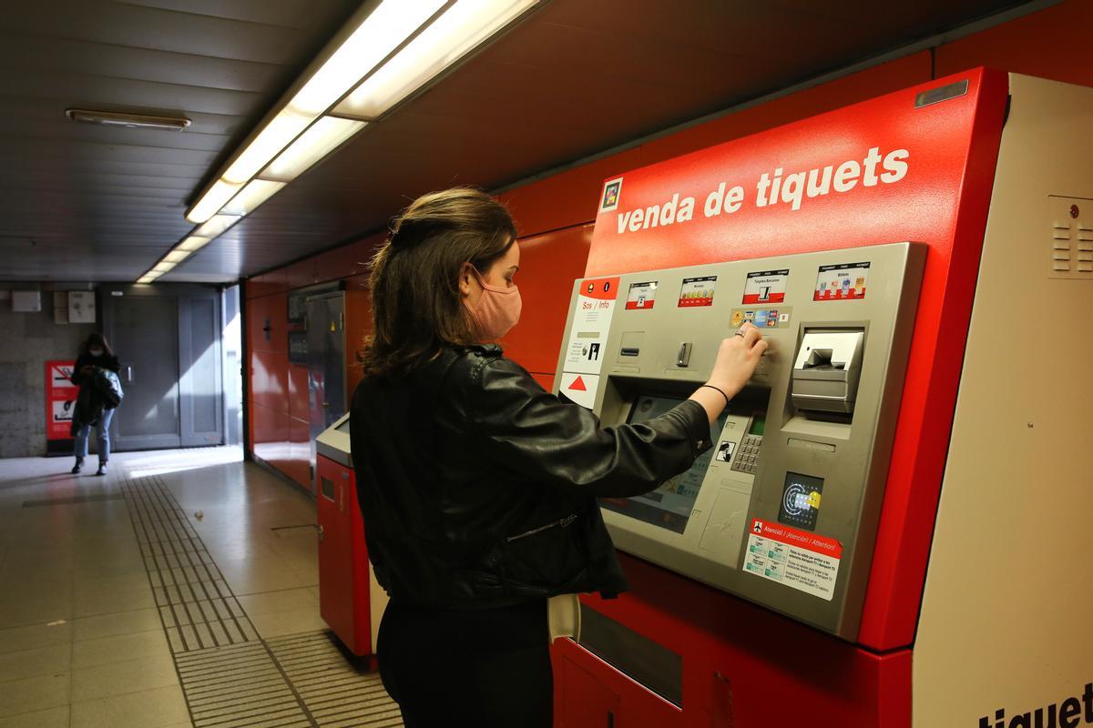 Una joven trata de adquirir un título de transporte en el metro de Barcelona