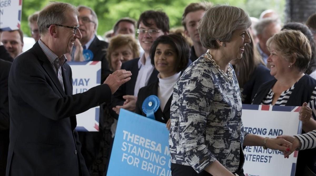 La primera ministra britanica y lider del Partido Conservador, Theresa May, saluda a sus partidarios a su llegada a un acto de campaña.