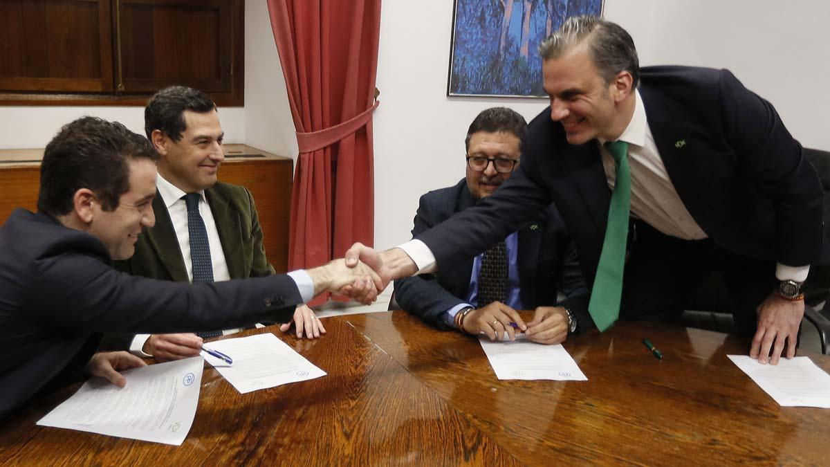 Los secretarios generales del PP, Teodoro García Egea, y de Vox, Francisco Javier Ortega Smith, estrechan las manos delante de los líderes andaluces del PP, Juanma Moreno y de Vox, Francisco Serrano, durante una reunión esta tarde en el Parlamento de Andalucía para firmar el acuerdo.