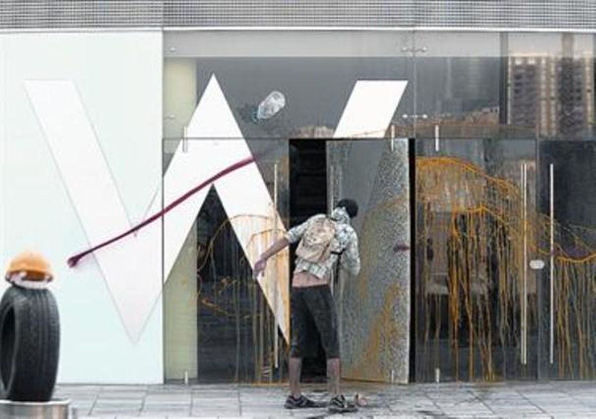 Un manifestante lanza pintura contra una de las fachadas del hotel, al finalizar la protesta lúdica, ayer. Un manifestante lanza pintura contra una de las fachadas del hotel, al finalizar la protesta lúdica, ayer.