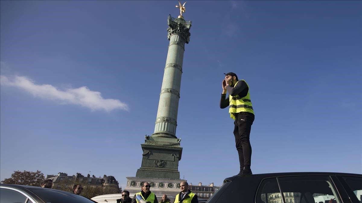 Fotografia del 17 de noviembre del 2018, cuando arrancó las protestas de los ’chalecos amarillos’, en la que un hombre , subido en un coche, se dirige a los manifestantes en la plaza de la Bastilla, en París.