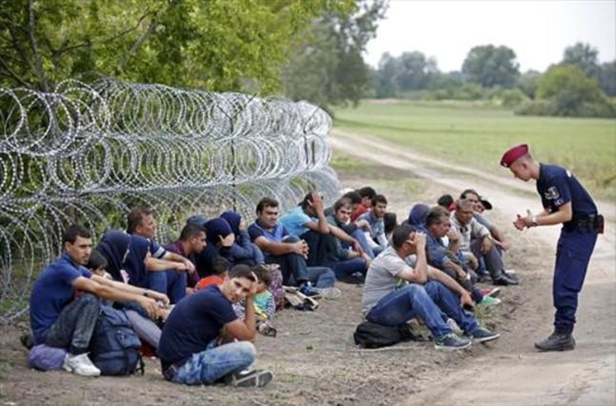 Un policía húngaro con varios detenidos tras cruzar desde Serbia. Un policía húngaro con varios detenidos tras cruzar desde Serbia.