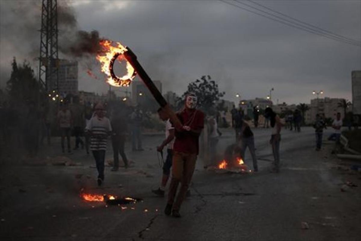 Jóvenes palestinos queman neumáticos en unos choques con soldados.