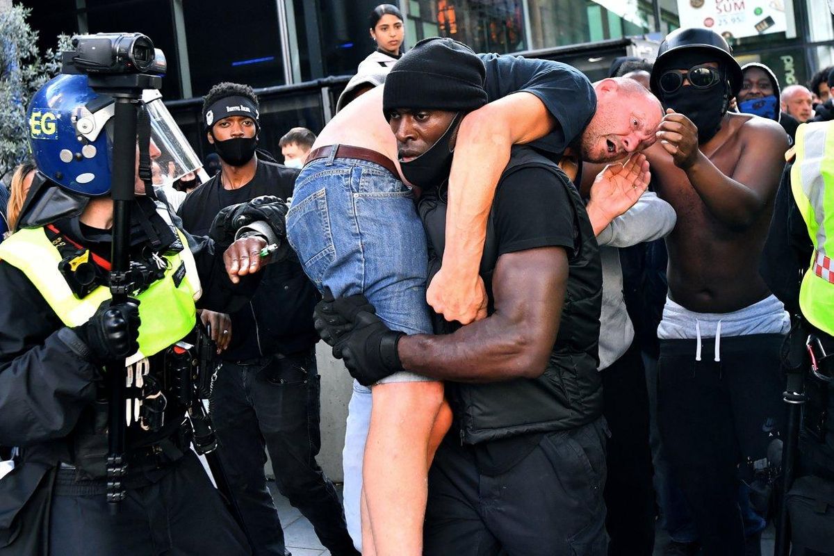 Patrick Hutchinson, con el manifestante blanco ultra herido al hombro, en Londres, el pasado sábado. Patrick Hutchinson, con el manifestante blanco ultra herido al hombro, en Londres, el pasado sábado.