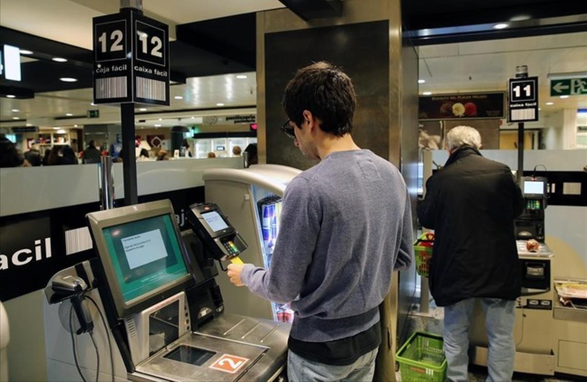 Un cliente chequea sus productos en el supermercado de El Corte Inglés de plaza de Catalunya, el viernes. 