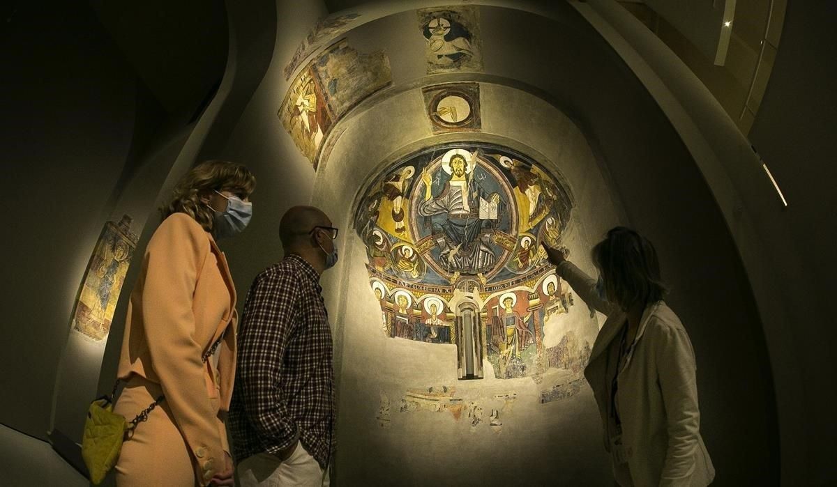 Visitantes con mascarilla, ante el ábside de Sant Climent de Taüll, ayer en la reapertura del MNAC tras el confinamiento. Visitantes con mascarilla, ante el ábside de Sant Climent de Taüll, ayer en la reapertura del MNAC tras el confinamiento.
