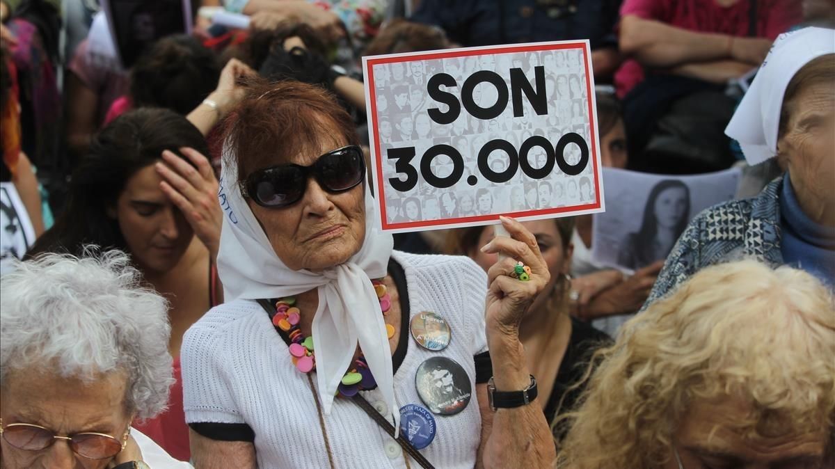 Una mujer sostiene un cartel en referencia a los 30.000 desaparecidos mientras escucha el veredicto por los crímenes cometidos en la ESMA, en Buenos Aires, el 29 de noviembre. Una mujer sostiene un cartel en referencia a los 30.000 desaparecidos mientras escucha el veredicto por los crímenes cometidos en la ESMA, en Buenos Aires, el 29 de noviembre.